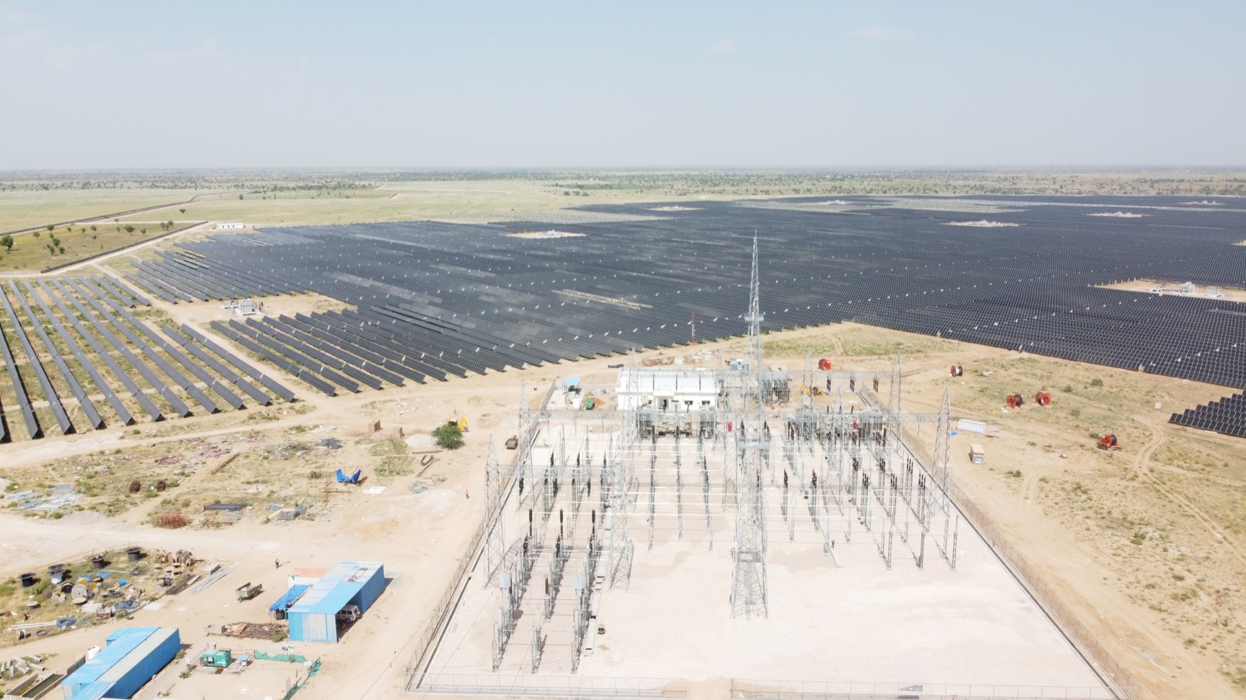 Large solar power plant with electrical substation infrastructure.